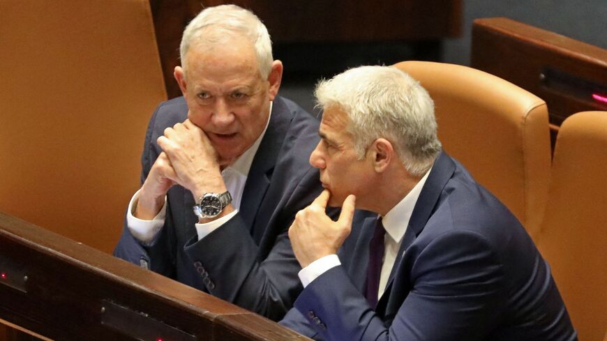 Israel's Defense Minister Benny Gantz (L) and Foreign Minister Yair Lapid attend a preliminary vote on a bill to dissolve parliament and call an early election at the Knesset, Jerusalem on June 22, 2022.