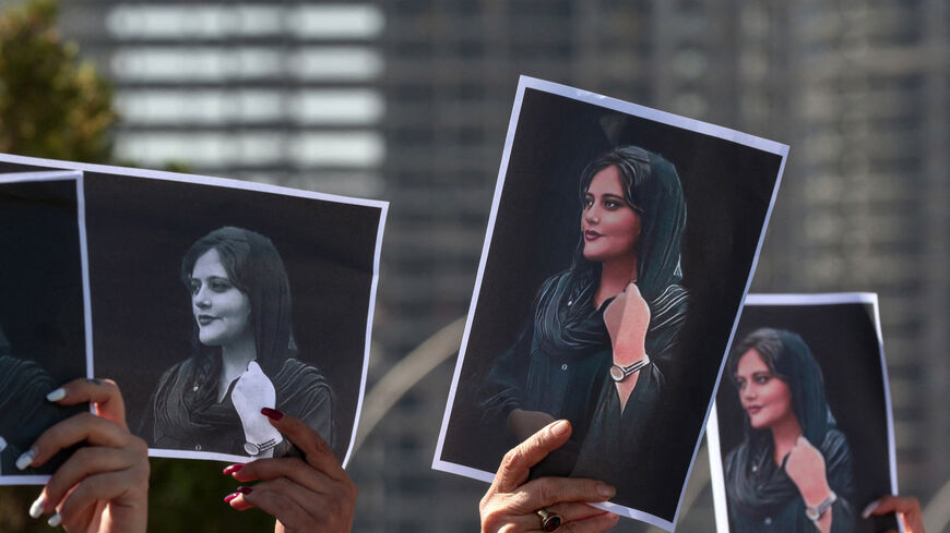 Women hold up signs depicting Mahsa Amini, who died while in the custody of Iranian authorities, Irbil, capital of Iraq's autonomous Kurdistan region, September 24, 2022.
