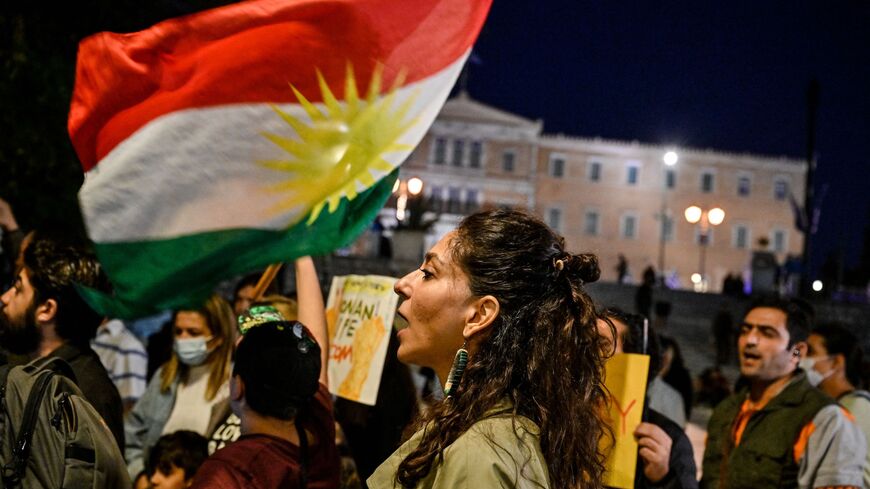 Iranian refugees and Iranians living in Greece wave a Kurdish flag while singing the Iranian protest song of Shervin Hajipour during a demonstration to commemorate 40 days from the death of Iranian Mahsa Amini while in police custody in Iran, in central Athens on Oct. 29, 2022. 