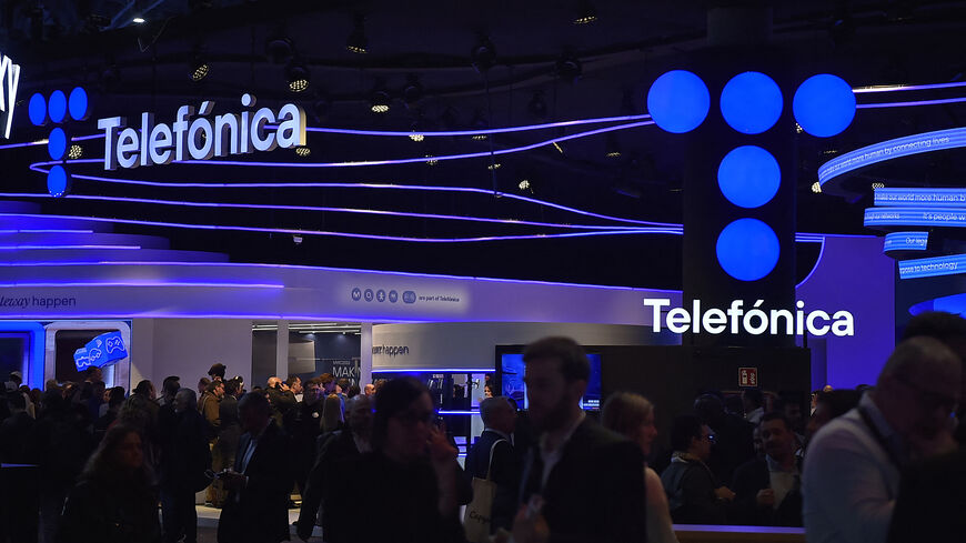 People visit the stand of Spanish company Telefonica at the Mobile World Congress (MWC), the telecom industry's biggest annual gathering, in Barcelona on February 27, 2023. (Photo by Pau BARRENA / AFP) (Photo by PAU BARRENA/AFP via Getty Images)