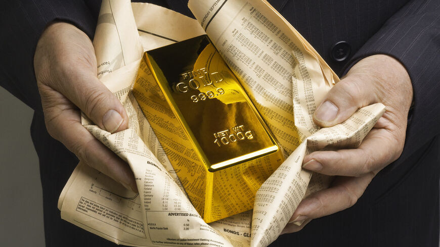 Gold bar wrapped in a financial newspaper.