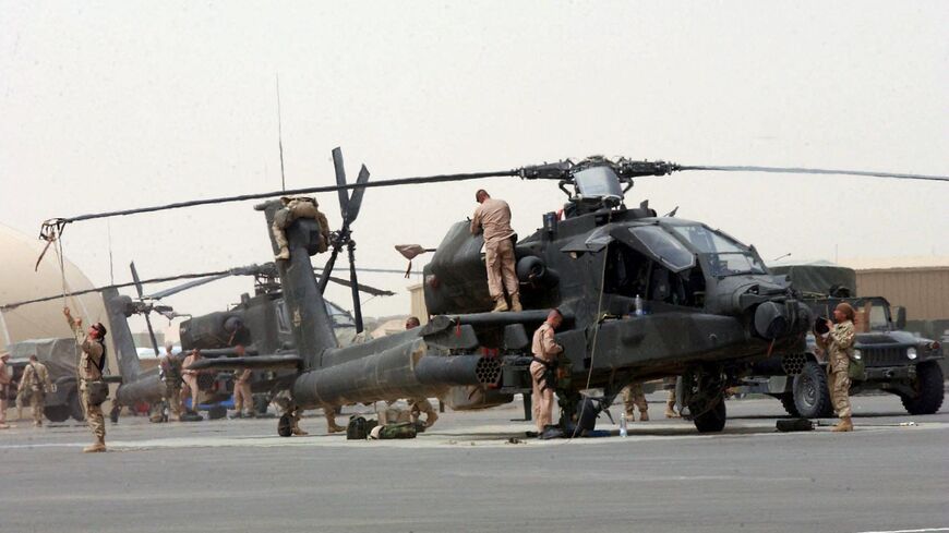 US Army helicopter crew from the 101st Airborne Division prepares the Apache attack helicopter at the the Camp Udairi airfield in preparation for a mission to Iraq 20 March 2003. 