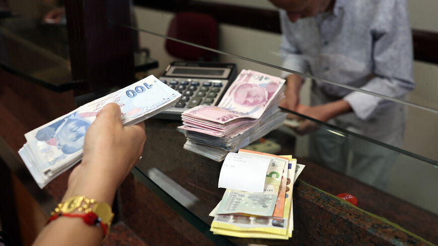 A customer buys US dollars in exchange for Turkish lira at an exchange office, Ankara, Turkey, July 20, 2023.