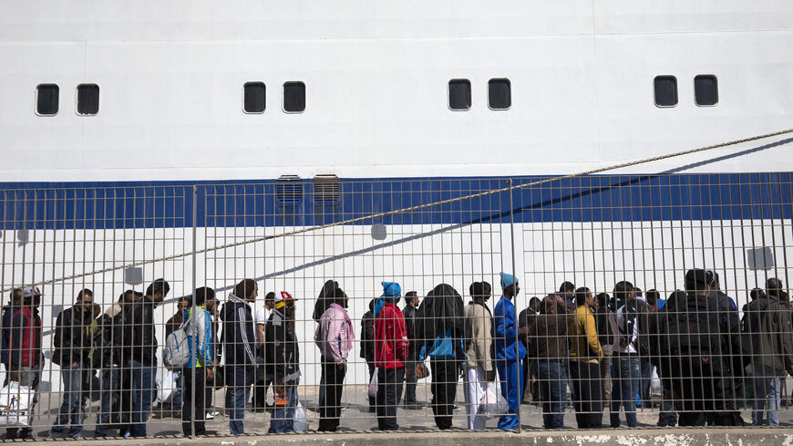 Migrant men wait to board a ship bound for Sicily from Lampedusa, Italy, April 22, 2015. 