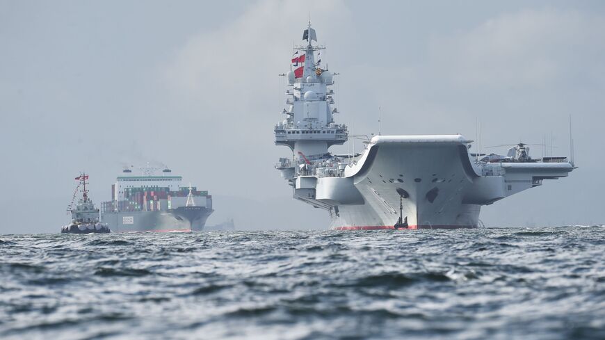 China's sole aircraft carrier, the Liaoning (R), arrives in Hong Kong waters on July 7, 2017.