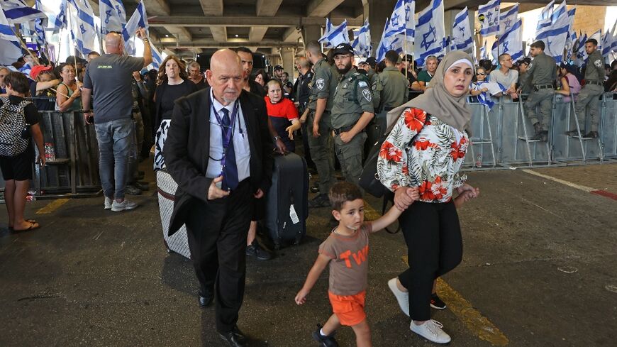 People leave Israel's Ben Gurion Airport near Lod as anti-government demonstrators rally in July 2023