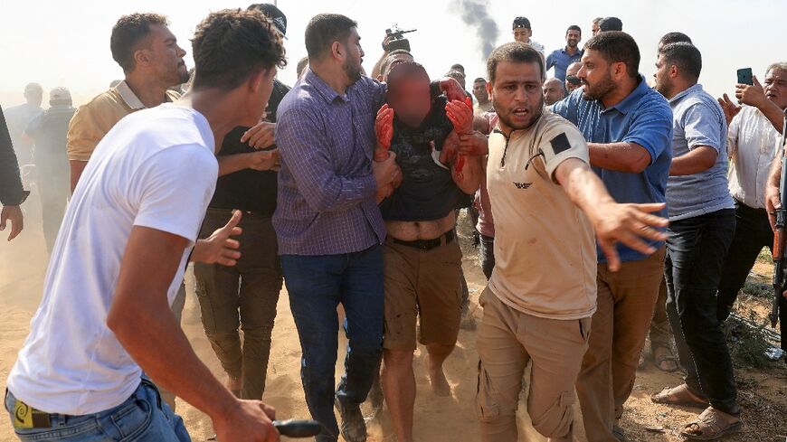 Palestinians curround a reportedly captured and injured Israeli man, in Khan Yunis in the southern Gaza Strip, on October 7, 2023