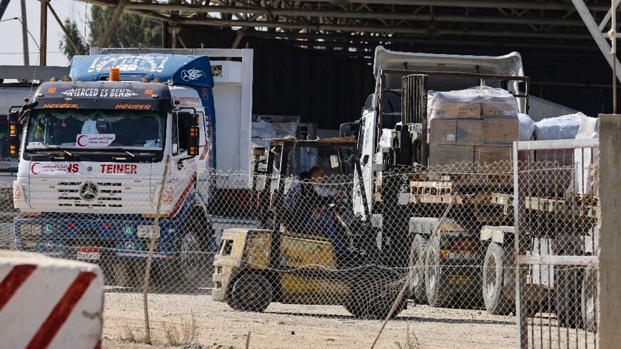 Workers unload lorries carrying humanitarian aid after they entered the Gaza Strip