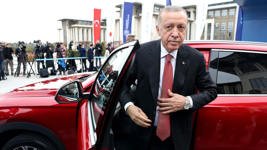 Turkey's President Recep Tayyip Erdogan stands next to his Togg T10X, Turkey's first domestically-produced electric car, after receiving it from the company at the Presidential Complex in Ankara, on April 3, 2023. (Photo by Adem ALTAN / AFP) (Photo by ADEM ALTAN/AFP via Getty Images)