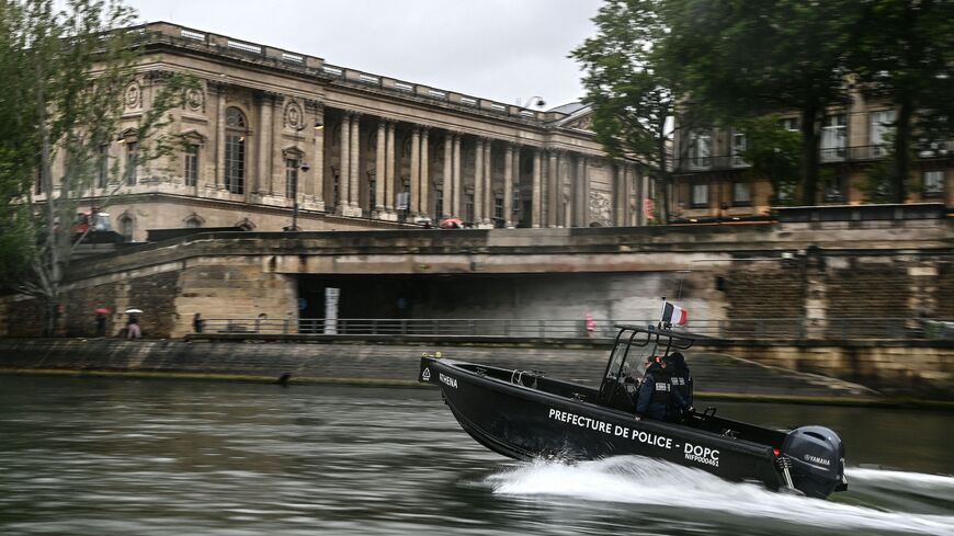Policemen from the River Brigade (Brigade Fluviale) patrol on a boat on the Seine River, in front of the Louvres' museum in Paris on May 9, 2023.