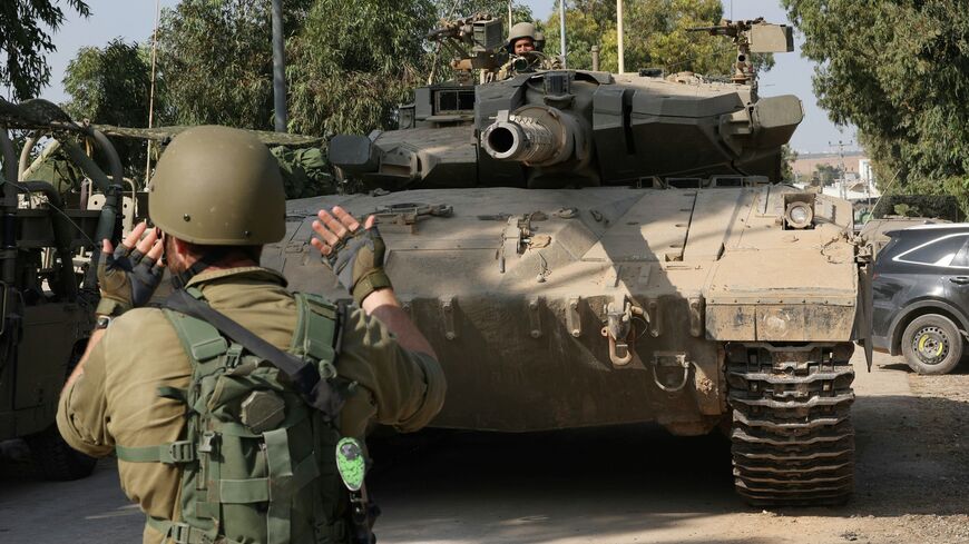 Israeli tanks leave the kibbutz of Kfar Aza in southern Israel after inspecting the area on the border with the Gaza Strip, on October 10, 2023. Israel pounded Hamas targets in Gaza on October 10 and said the bodies of 1,500 Islamist militants were found in southern towns recaptured by the army in gruelling battles near the Palestinian enclave. (Photo by JACK GUEZ / AFP) (Photo by JACK GUEZ/AFP via Getty Images)