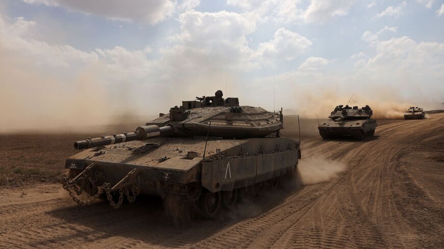 An Israeli Merkava battle tank moves in a convoy along the border with the Gaza Strip in southern Israel, October 13, 2023.