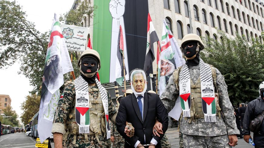 TOPSHOT - Members of the Iranian Basij forces stage a mock arrest of a man dressed like Israeli Prime Minister Benjamin Netanyahu during an anti-Israeli rally to show their solidarity with Palestinians in the capital Tehran on October 13, 2023. Thousands of Iranians took to the streets of Tehran on Friday in a show of support for Palestinians amid a bloody conflict between Israel and Hamas. (Photo by AFP) (Photo by -/AFP via Getty Images)