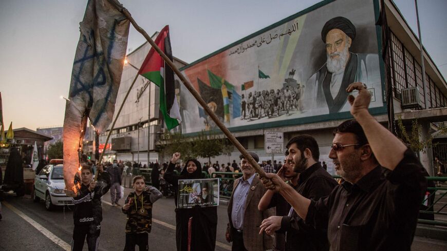 In the aftermath of the bombing of Gaza's Al-Ahli Baptist Hospital on Oct. 17, 2023, a pro-government demonstration on Oct. 18, 2023, in Tehran, Iran, includes protesters burning the flags of the United States and Israel as a display of solidarity with Palestine. 