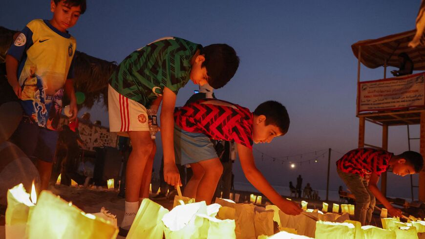 Children light candles during a solidarity vigil organized by Lebanon's Press Photographers Syndicate and the Ajial Social Communication Center, at the Ramlet al-Bayda beach in Beirut on October 22, 2023 in memory of killed Lebanese Journalist Issam Abdallah and in support of Palestinians amid the the ongoing battles between Israel and the Palestinian group Hamas in the Gaza Strip. (Photo by JOSEPH EID / AFP) (Photo by JOSEPH EID/AFP via Getty Images)