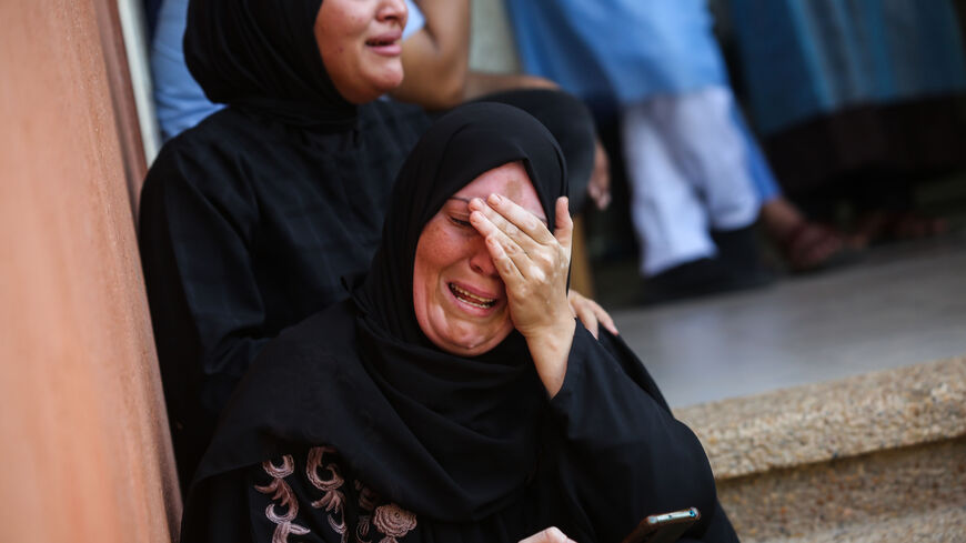 KHAN YUNIS, GAZA - OCTOBER 19: A woman cries as she bids farewell to the bodies of Palestinians killed during Israeli airstrikes on October 19, 2023 in Khan Yunis, Gaza. Gazans are evacuating to the south as advised by the Israeli government, ahead of an expected Israeli ground offensive. Israel has sealed off Gaza, leaving the entire population without fuel, water or aid, and launched sustained retaliatory air strikes, which have killed more than 2,000 people and some 400,000 displaced, after a large-scale