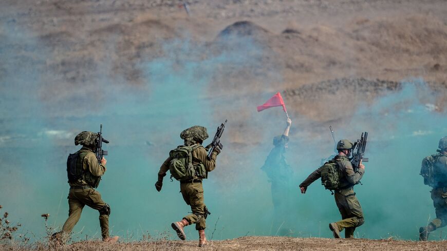 10/29/2023 Golan Heights, Israel. Israeli soldiers, as part of the 'Israeli Paratroopers Brigade,' experimented with colorful smoke during their battalion training at the Golan Heights on October 29, 2023, before subsequently returning to the Gaza border. (Photo by Dima Vazinovich / Middle East Images / Middle East Images via AFP) (Photo by DIMA VAZINOVICH/Middle East Images/AFP via Getty Images)