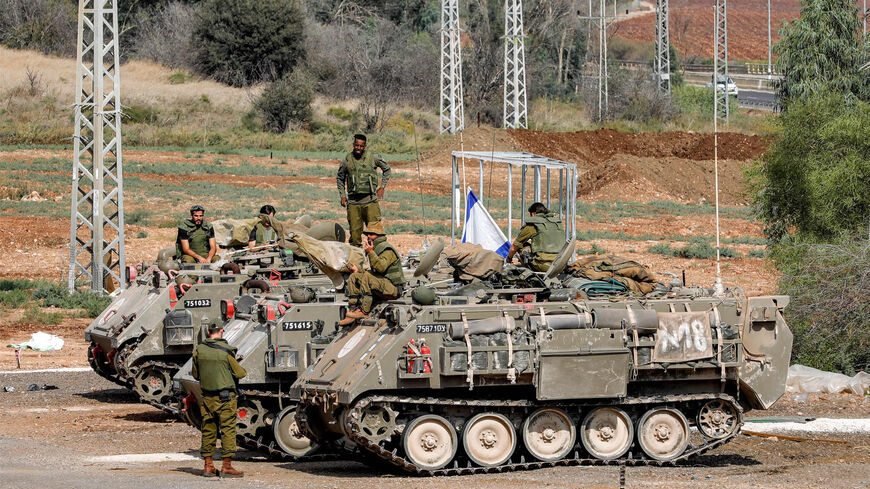 Israeli army soldiers gather by three tracked medical vehicles near the northern town of Kiryat Shmona close to the border with Lebanon, Oct. 31, 2023.