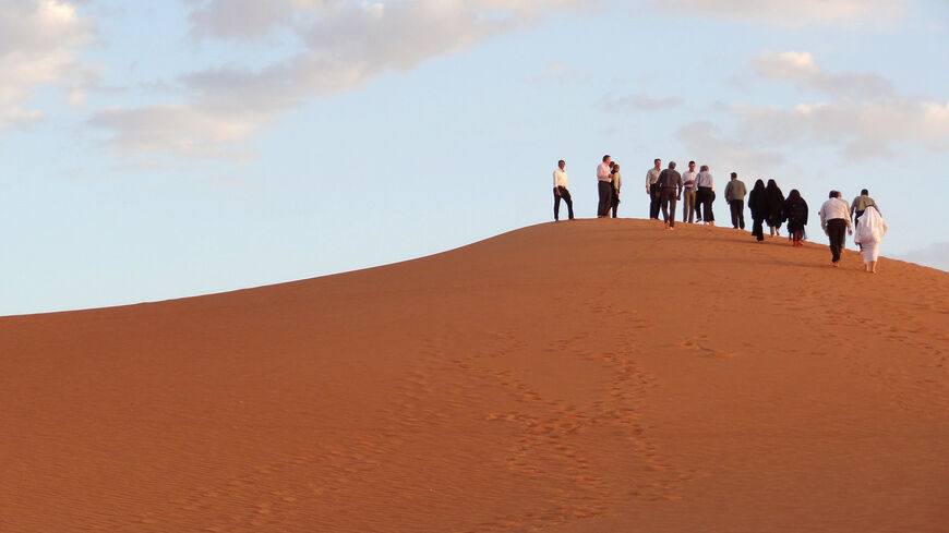 Visitors and Aramco staff climb a dune at Shaybah, the base for Saudi Aramco's Natural Gas Liquids plant and oil production in the surrounding Shaybah field in Saudi Arabia's remote Empty quarter desert close to the United Arab Emirates, on May 10, 2016. Despite collapsed global oil prices, production is expanding at Shaybah, as it is in other units of the company at the centre of the kingdom's Vision 2030 drive for diversification away from oil. The Saudi government plans to sell less than five percent of 