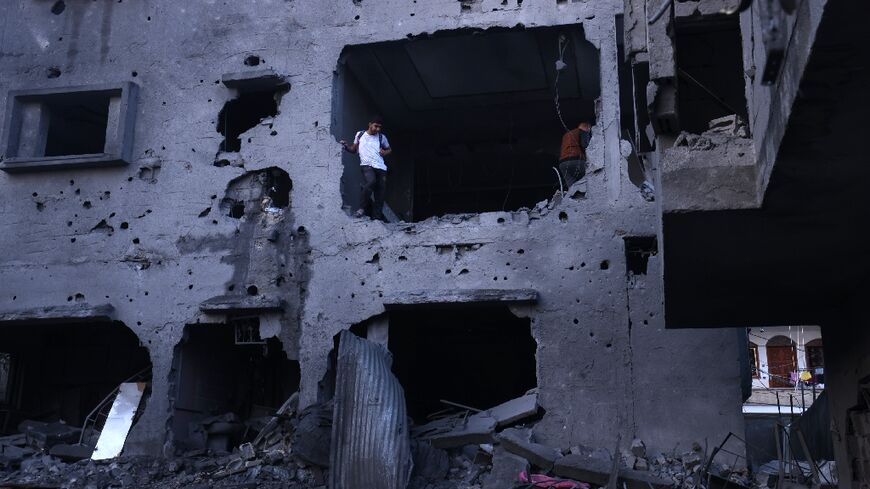 Palestinians inspect the rubble of a building after an Israeli airstrike on the Rafah refugee camp, in the southern Gaza Strip on October 17, 2023