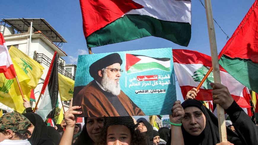 A girl holds up a sign showing Hassan Nasrallah, the leader of Lebanese Shiite movement Hezbollah, during a rally in solidarity with the Palestinians in Lebanon's southern city of Nabatieh