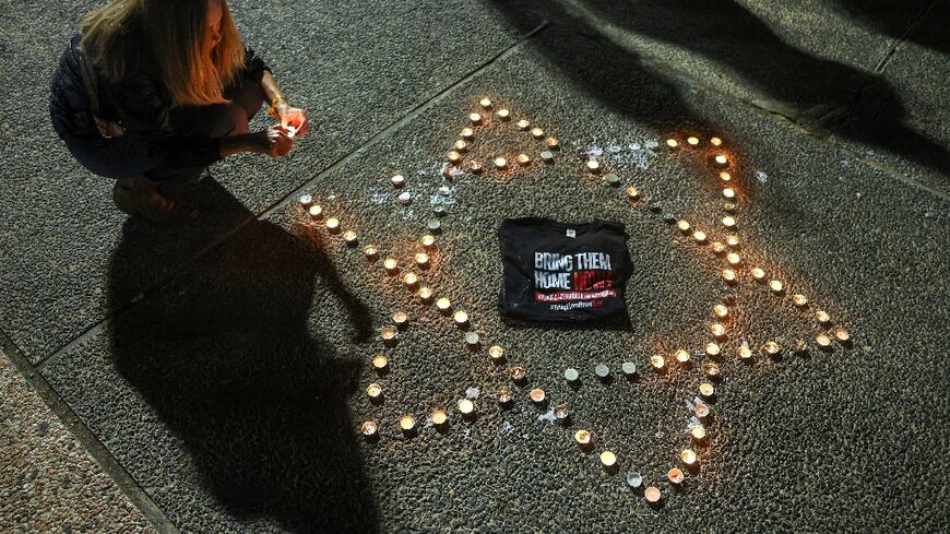 A woman lights candles in Tel Aviv, demanding the release of Israelis held hostage in Gaza