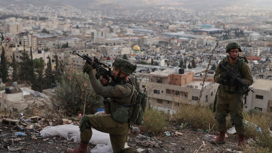 An Israeli soldier aims his rifle during a raid on Balata refugee camp in the occupied West Bank