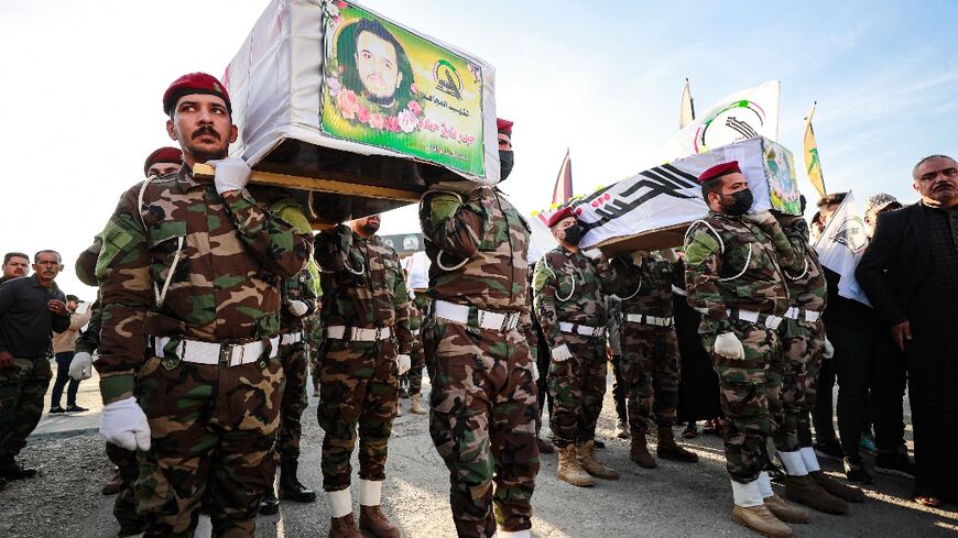 Hashed al-Shaabi soldiers carry the coffins of fighters killed in the US strikes