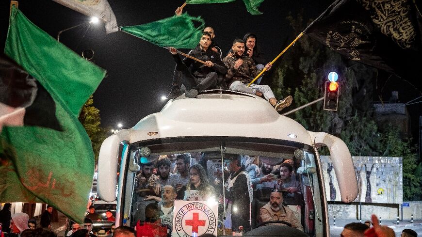 A crowd surrounds a Red Cross bus carrying Palestinian prisoners released from Israeli jails in exchange for hostages released by Hamas from the Gaza Strip, in Ramallah in the occupied West Bank