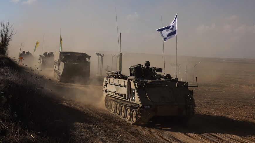 A convoy of Israeli military vehicles drives down a road at an undisclosed location on the border with the Gaza Strip on October 15, 2023.