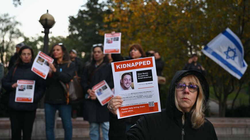 A woman holds a poster of Israeli hostage Omer Neutra during a memorial vigil for the Israeli people killed by Hamas during the October 7 attack, in New York City on November 1, 2023. Thousands of civilians, both Palestinians and Israelis, have died since October 7, 2023, after Palestinian Hamas militants based in the Gaza Strip entered southern Israel in an unprecedented attack triggering a war declared by Israel on Hamas with retaliatory bombings on Gaza. (Photo by ANGELA WEISS / AFP) (Photo by ANGELA WEI