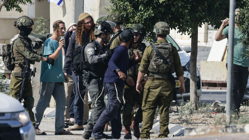 Israeli soldiers scuffle with Jewish settlers from the nearby Einav settlement, trying to storm the town of Deir Sharaf in the Nablus governorate of the occupied West Bank on Nov. 2, 2023, after an Israeli was killed when his car came under fire.