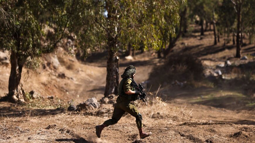 An Israeli soldier runs to a position during a drill in the annexed Golan Heights on Nov. 9, 2023.