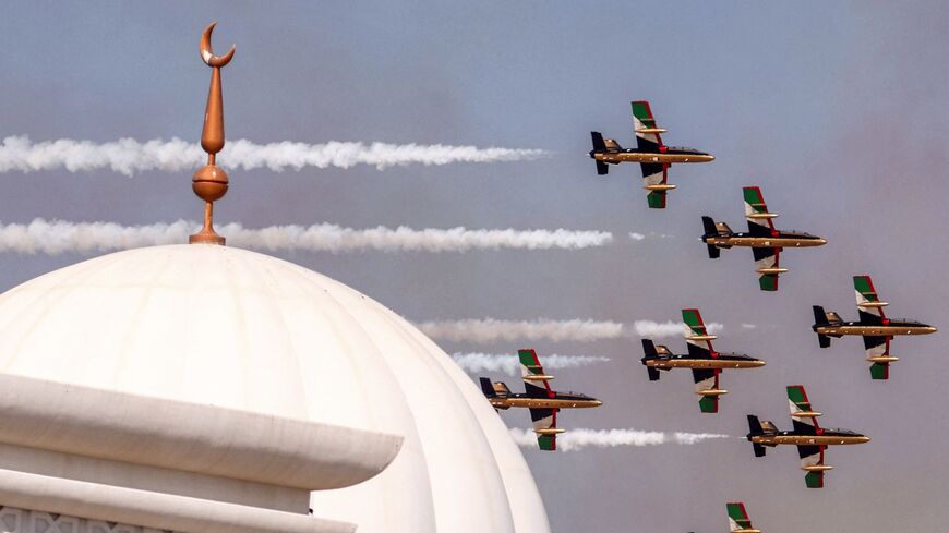 Aermacchi MB-339 trainer aircraft of the Fursan al-Emarat (UAE Knights) aerobatics team release smoke as they fly over during the Dubai Airshow at Dubai World Central, Al-Maktoum International Airport, Nov. 14, 2023.