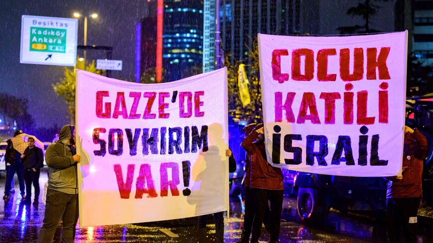 Turkish football supporters hold banners reading "There is a genocide in Gaza" and "Children killer Israel" during a demonstration to demand a stop to the bombings in Gaza in front of the Israeli consulate in Istanbul, on November 18, 2023 amid ongoing battles between Israel and the Palestinian Hamas movement in the Gaza Strip. (Photo by YASIN AKGUL / AFP) (Photo by YASIN AKGUL/AFP via Getty Images)
