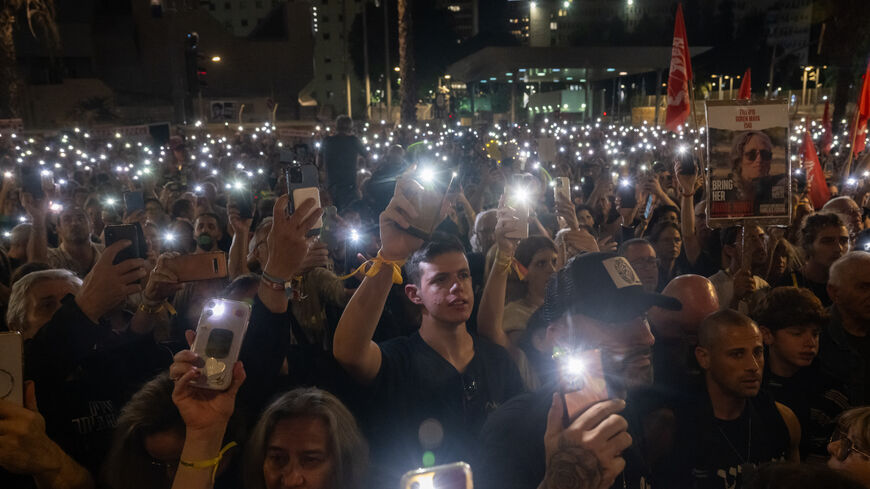 TEL AVIV, ISRAEL - NOVEMBER 18: Thousands of people and the families of kidnapped Israelis hold up their mobile phones with the torch light to sing the national anthem during a rally demanding that Israeli Prime Minister Benjamin Netanyahu secures the release of the hostages, outside The Museum of Modern Art known as the 'The Hostages and Missing Square' on November 18, 2023 in Tel Aviv, Israel. Families and supporters of the hostages taken by Hamas in its Oct 7 attack commenced a multi-day march from Tel A