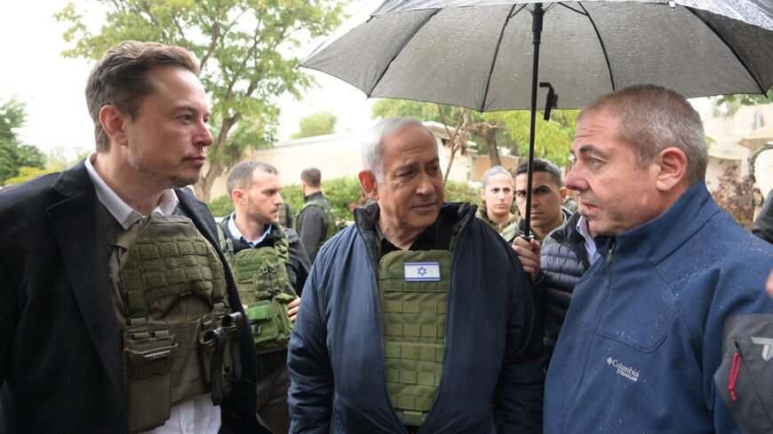 In this handout image provided by the GPO, Israel's Prime Minister Benjamin Netanyahu (C) takes Elon Musk (L) on a tour of Kibbutz Kfar Aza after the Oct. 7 massacre took place there, on Nov. 27, 2023 in Kfar Aza, Israel.  