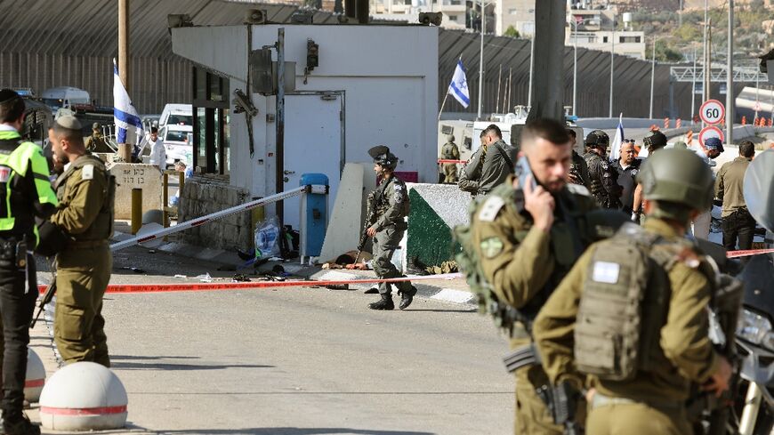 Israeli officers secure the scene after an attack by gunmen on a checkpoint guarding the access to road tunnels linking the occupied West Bank and Jerusalem 