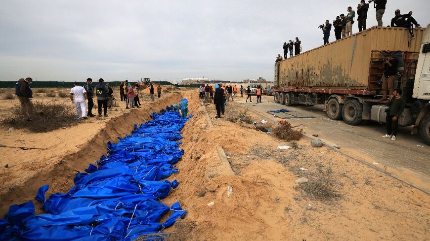 Dozens of blue-wrapped bodies are placed in a mass grave