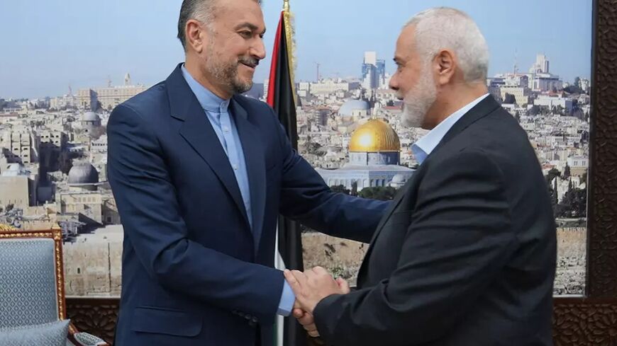 Iranian Foreign Minister Hossein Amir Abdollahian (L) greets Hamas political bureau chief Ismail Haniyeh in Qatar on Tuesday. Iran backs the militant group but denies involvement in its October 7 attacks on Israel