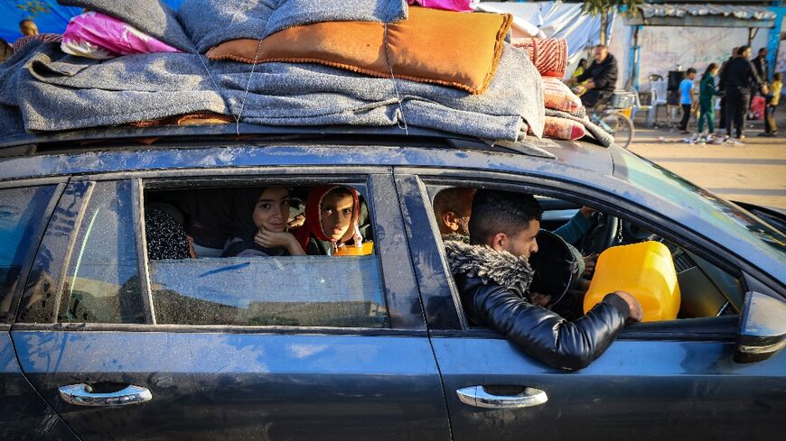 Palestinians who had taken refuge in temporary shelters return to their homes in eastern Khan Yunis, the southern Gaza Strip, during the first hours of a four-day truce between Israel and Hamas militants