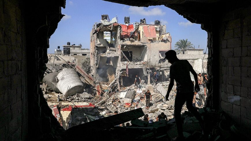 A Palestinian stands in front of a bombed-out building in Khan Yunis