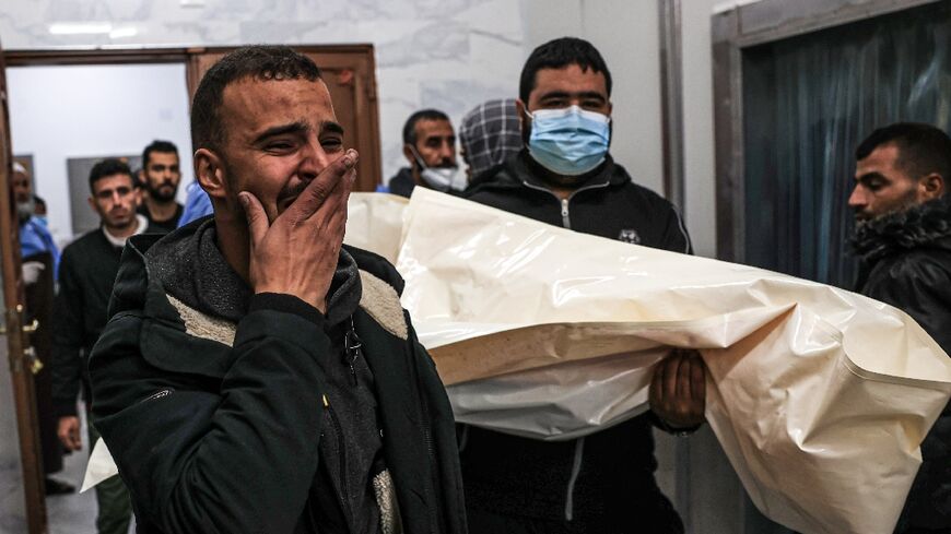 Mourners move the body of Palestinian, killed during an Israeli strike, from the EU hospital in Khan Yunis, southern Gaza