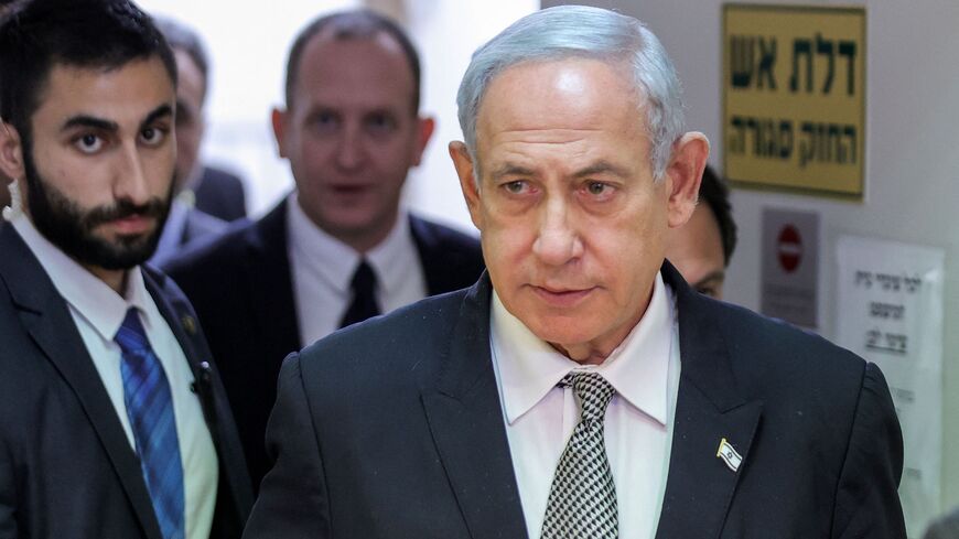 Israeli Prime Minister Benjamin Netanyahu (R) walking during a hearing at the Magistrate's Court in Rishon Lezion on January 23, 2023.