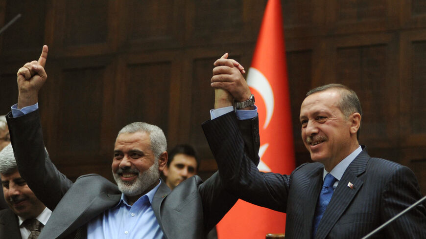 The Gaza Strip's Hamas Prime minister Ismail Haniya (L) and his Turkish counterpart Recep Tayyip Erdogan salute together the lawmakers of Erdogan's Islamic-rooted Justice and Development Party at the Parliament in Ankara on January 3, 2012. Haniyeh's visit was a show of solidarity with the Islamic aid group IHH, which had planned to send the Mavi Marmara vessel with another Gaza flotilla last year but then dropped the plan. AFP PHOTO/ADEM ALTAN (Photo by Adem ALTAN / AFP) (Photo by ADEM ALTAN/AFP via Getty 