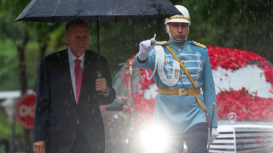 Turkish President Tayyip Erdogan (L) arrives under the rain to the Turkish Parliament to take oath of office after his election win at the parliament in Ankara, Turkey, on June 3, 2023. Turkey's Recep Tayyip Erdogan was sworn in for a third term as president on June 3, promising to serve "impartially" after winning a historic runoff election to extend his two-decade rule. (Photo by Adem ALTAN / AFP) (Photo by ADEM ALTAN/AFP via Getty Images)