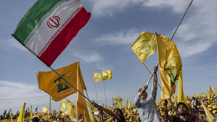 People wave Hezbollah and Iranian flags at a rally in Baalbek, Lebanon, May 13, 2022.