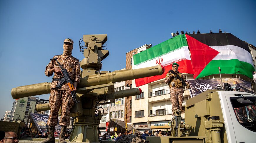 11/24/2023 Tehran, Iran. Two Islamic Revolutionary Guard Corps (IRGC) armed military personnel are monitoring an area while standing guard next to an Iranian Majid anti-aircraft missile system during the Ela Beit Al-Moghaddas (Al-Aqsa Mosque) military rally in Tehran, Iran. (Photo by Hossein Beris / Middle East Images / Middle East Images via AFP) (Photo by HOSSEIN BERIS/Middle East Images/AFP via Getty Images)