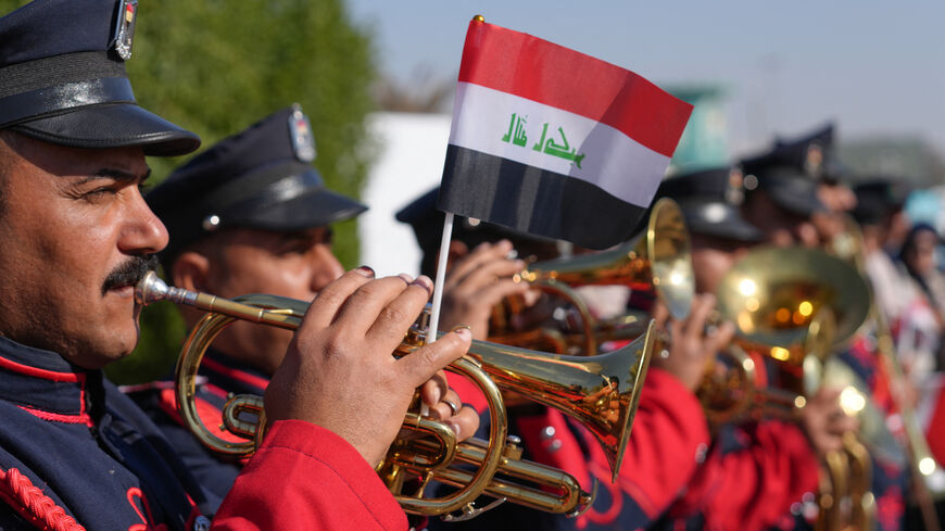 A military marching band plays outside during the first provincial council elections in a decade, at a polling station in the central city of Najaf, on December 18, 2023. The vote comes at a time of widespread disillusionment among the country's 43 million inhabitants, with endemic corruption eating away at the oil-rich nation. (Photo by Qassem al-KAABI / AFP) (Photo by QASSEM AL-KAABI/AFP via Getty Images)