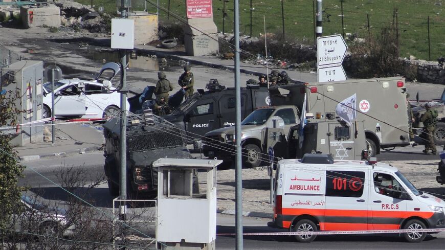 Israeli troops cordon off a road junction north of the West Bank city of Hebron after shooting dead a Palestinian motorist they suspected of preparing to attack them